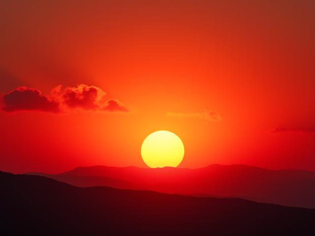 Espectacular puesta de sol sobre el desierto, con colores cálidos y siluetas.